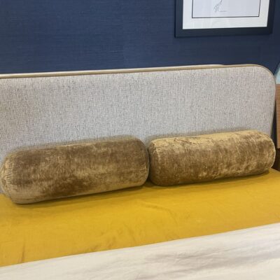Two bolster cushions in bronze velvet
