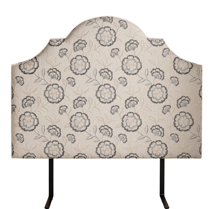 Elegant, curved beige headboard with a floral pattern featuring grey and cream flowers. The design conveys a vintage and classic feel.
