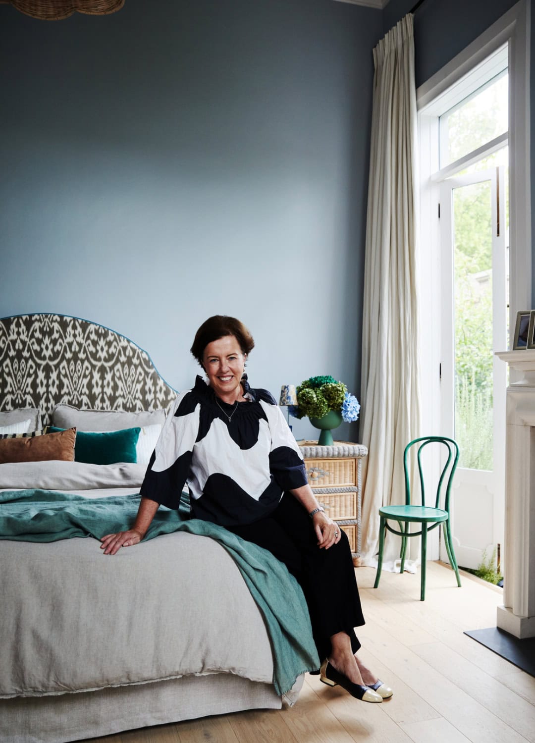 Heatherly Design Founder and Director Georgie Leckey sitting on a bespoke bed in a Melbourne Residence